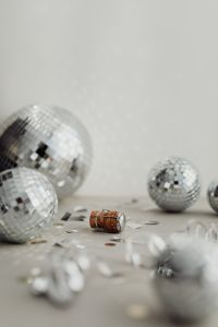 Kaboompics - Soft-Focus Disco Balls, Champagne Cork and Metallic Confetti on Pale Floor