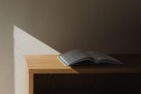 Kaboompics - Open book on oak shelf corner with dramatic sunlight
