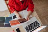 Kaboompics - Woman Writing Notes beside Laptop and Color Swatches at a Home Office Desk