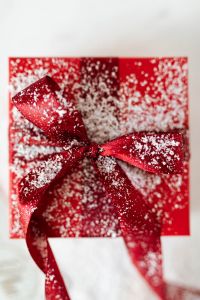Kaboompics - Close-Up Red Satin Bow with Snow-Like Glitter for Christmas Gift Wrapping