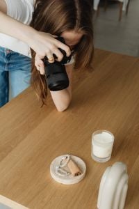 Kaboompics - Young Female Photographer Photographing Candle and Decor Setup