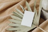 Kaboompics - Blank Branding Card on Dried Palm Leaves with a Stone Candle Holder
