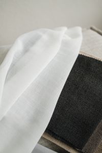 Kaboompics - White Sheer Fabric Draped Over Dark Textile Swatches