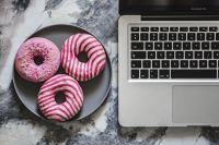 Kaboompics - Colorful Donuts On Plate Beside Laptop