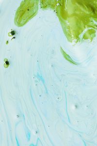 Kaboompics - Pale Blue Fluid Texture with a Green Paint Swirl and Open Space for Creative Backgrounds