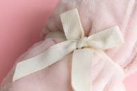 Kaboompics - Soft Pink Blanket Tied With Ribbon Close Up