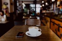 Kaboompics - Cup of coffee on table in cafe, iPhone mobile phone