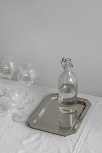 Kaboompics - Glass Bottle and Glassware on Silver Tray over White Tablecloth