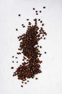 Kaboompics - Coffee Beans Scattered on White Texture with Copy Space for Cafe Menus