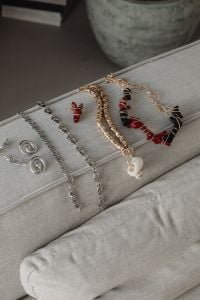Kaboompics - Assorted Silver and Beaded Jewelry on a Neutral Sofa