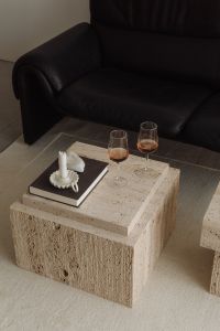 Kaboompics - Open Book on Travertine Table beside Black Sofa Arm