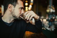 Kaboompics - Handsome young man having a whiskey in a pub