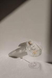 Kaboompics - Clear Perfume Bottle Casting a Shadow on a White Surface