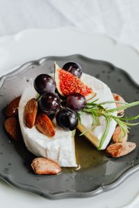 Kaboompics - Close-Up Camembert Wedges with Dark Grapes and Rosemary