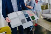 Kaboompics - Furniture Designer Holding a Board of Upholstery Fabrics in the Showroom