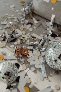 Kaboompics - Silver Party Confetti and Ribbon Scattered Across a Gray Sofa