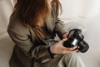 Kaboompics - Young Female Photographer Reviewing Photos on DSLR Camera