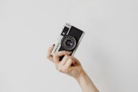 Kaboompics - Film Camera Presented on an Open Palm Against White