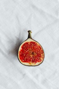 Kaboompics - Vertical Single Fig Cut Open with White Linen Copy Space