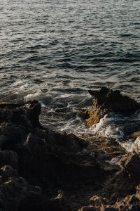 Kaboompics - Foamy Sea Water Around Dark Shore Rocks