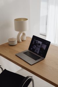 Kaboompics - Laptop And Sculptural Lamp On Wooden Desk By Window