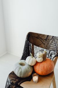 Kaboompics - Halloween Pumpkins and Candle on a Spiderweb Chair