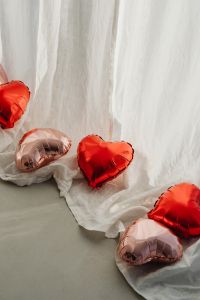 Kaboompics - Foil Heart Balloons on White Sheer Fabric for Valentine's Day
