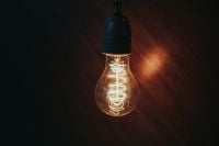 Kaboompics - Single Glowing Edison Bulb against a Dark Wall, Warm Ambient Lighting Background