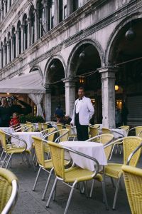 Kaboompics - Man in White Jacket Among Outdoor Cafe Tables in Venice