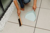 Kaboompics - Woman Sweeping a Tiled Floor Beside White Decorative Stones