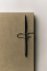 Kaboompics - Beige Notebook with Pen and Binder Clip