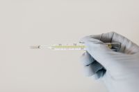 Kaboompics - Glass Thermometer Held in Medical Glove with White Copy Space, Healthcare Background
