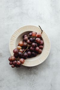 Kaboompics - Close-Up of Red Grapes in a Cream Fluted Bowl