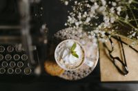 Kaboompics - Overhead Coffee Break Still Life with Ornate Cup, Typewriter Keys, Eyeglasses and White Flowers
