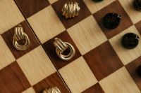 Kaboompics - Gold Metal Chess Pieces on Wooden Chessboard