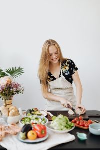 Kaboompics - Woman Slicing Rustic Bread on a Cutting Board in the Kitchen