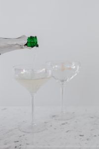Kaboompics - Champagne Bottle Pouring Into Two Coupe Glasses