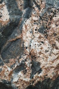 Kaboompics - Mottled Gray, Cream and Rose Coastal Stone with Black Mineral Flecks, Abstract Rock Background