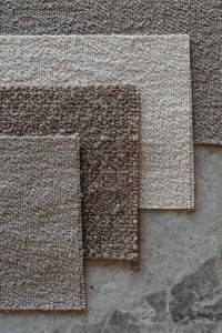 Kaboompics - Overlapping Brown and Beige Bouclé Upholstery Fabric Swatches on Stone