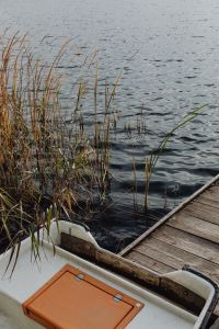 Kaboompics - White Rowboat Moored by a Wooden Lakeside Dock