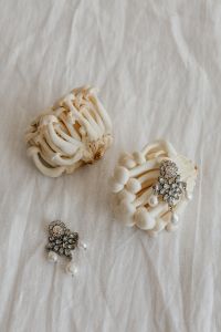 Kaboompics - White Mushrooms with Decorative Brooches on White Fabric