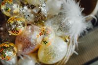 Kaboompics - Floral Glass Egg Ornaments and White Feathers in a Shallow Easter Basket, Macro Detail