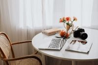 Kaboompics - Laptop, DSLR Camera and Notebooks on a Round Home Office Table