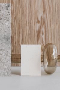 Kaboompics - Vertical Blank Business Card beside Smoked Glass Vase and Marble Slab, Wood Backdrop