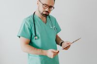 Kaboompics - Doctor Reviewing Clipboard in Side View