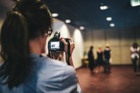 Kaboompics - Woman in glasses taking a photo with a camera