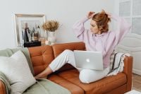 Kaboompics - Woman Tying Her Hair While Working on a Laptop