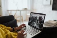 Kaboompics - Woman Typing on Laptop from Sofa in a Bright Home Office Living Room
