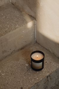 Kaboompics - Lit Black Candle on a Textured Concrete Step