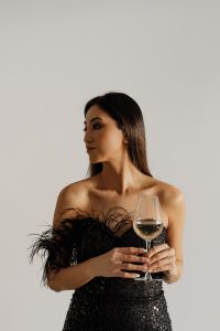 Kaboompics - Close-Up Wine Night Detail of Woman Holding a Stemmed Glass over Black Sequins